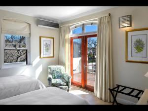 Un dormitorio con una cama y una silla y una ventana. en 10 Villefranche, en Franschhoek 21 fotos más