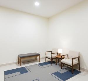 a waiting room with chairs and a bench at Premiere Suites - Brookfield in Bengaluru