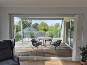 un soggiorno con patio arredato con tavolo e sedie. di Sunny Flensbo Apartment a Flensburgo