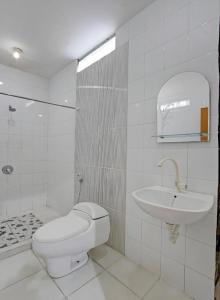 a white bathroom with a toilet and a sink at OYO 91920 Pondok'ku Inn in Yogyakarta