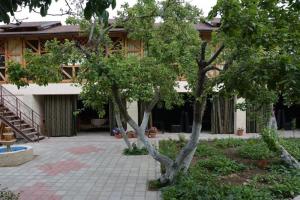a building with two trees in a courtyard at Guest House Albatros in Cholpon-Ata +59 photos