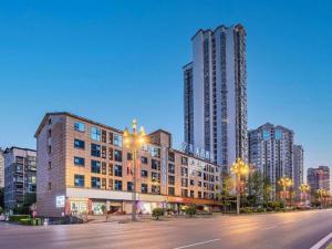 an empty street in a city with tall buildings at 7 Days Premium·Guangan Chaoyang Avenue in Guang'an