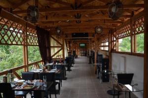 a dining room with tables and chairs and windows at Guest House Albatros in Cholpon-Ata