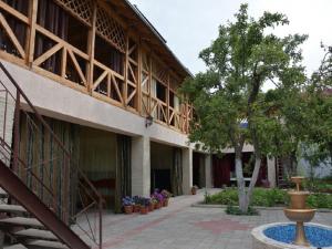 a building with a staircase and a tree and a fountain at Guest House Albatros in Cholpon-Ata