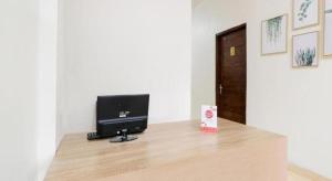 un ordinateur installé au-dessus d'un bureau en bois dans l'établissement OYO 2118 Fh Stay, à Salakan 52 autres photos