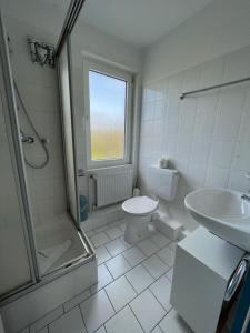 a bathroom with a toilet and a sink and a shower at Haus Nordseegruß 2 in Cuxhaven +7 photos
