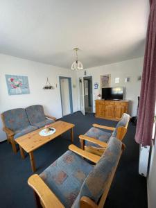 Una sala de estar con un sofá, una mesa y sillas. en Haus Nordseegruß 3, en Cuxhaven