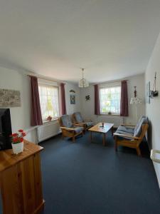 Una sala de estar con sillas, un televisor y una mesa. en Haus Nordseegruß 3, en Cuxhaven 9 fotos más