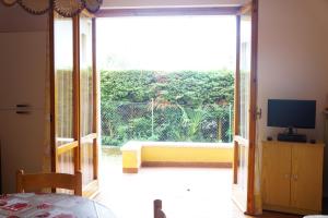a room with a large sliding glass door with a television at Atlantic in Bardolino