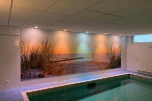 a swimming pool with a painting of the ocean at Knechtsand 402 in Cuxhaven