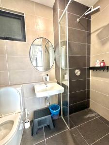 une salle de bain avec un lavabo et une douche avec un miroir dans l'établissement D'Pristine 4 bedder apartment opposite Legoland and Medini mall, à Iskandar Puteri 14 autres photos