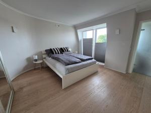 una camera da letto bianca con un letto e una finestra di Sunny Flensbo Apartment a Flensburgo