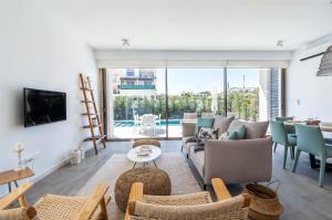 una sala de estar con un sofá y sillas en Azure Luxe Villas, en Protaras