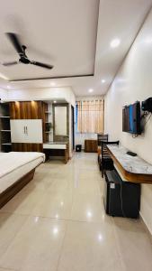 a room with a bed and a desk and a tv at YATRI NIVAS SAGARA ( AC AND NON-AC DELUXE ROOMS) in Sāgar