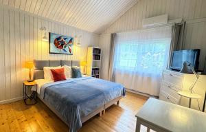 a bedroom with a bed and a flat screen tv at Dom w Starym Sadzie z basenem i sauną - Beskid Wyspowy in Nowe Rybie