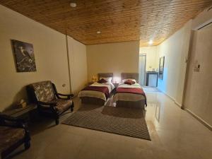 two beds in a room with a couch and a chair at Ramses Tafilah Lodge نزل رمسيس الطفيلة in Tufailah +106 photos