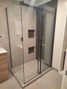 y baño con cabina de ducha de cristal. en The Mews, en Rolleston