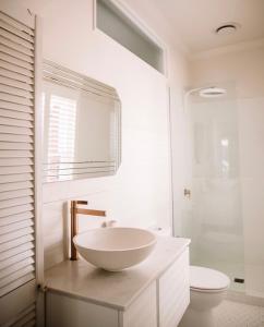 Un baño blanco con lavabo e inodoro. en Olive Cottage Rankin, en Bathurst 29 fotos más