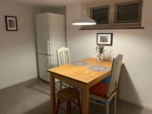 una cucina con un tavolo di legno con sedie e un frigorifero di Villa Room a Malmö 1 altra foto