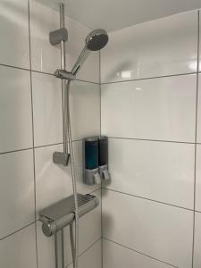un bagno con doccia e piastrelle bianche di Villa Room a Malmö