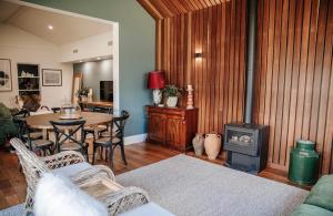 a living room with a table and a wood stove at Olive Cottage Rankin in Bathurst