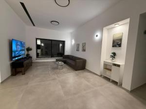 a living room with a couch and a flat screen tv at וילה יובל in Yuval