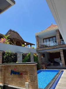 a house with a swimming pool next to a house at Mara inn in Nusa Dua