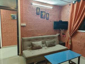 乌杜皮UDUPI HOMESTAY - Sunrise Home的带沙发、桌子和电视的客房