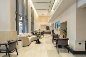 a lobby with a couch and chairs and a table at Wachi Hotel in Songkhla