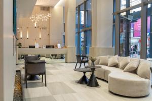 a lobby with a couch and chairs in a building at Wachi Hotel in Songkhla