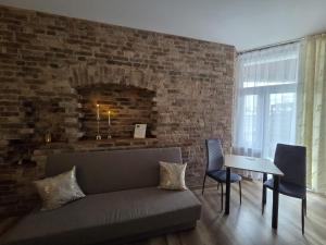 a living room with a couch and a brick wall at Placeo in Katowice