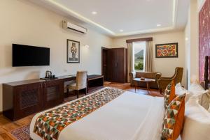 a hotel room with a bed and a desk at The Colonial - A Lake View Hotel in Udaipur in Udaipur