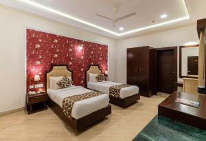 a hotel room with two beds and a red wall at The Colonial - A Lake View Hotel in Udaipur in Udaipur