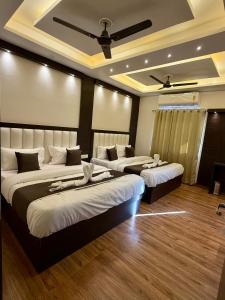 a hotel room with three beds in a room at Hotel KABIR ROYAL in Amritsar +41 photos