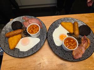 two plates of breakfast food on a wooden table at Bluebell Hotel in Blackpool