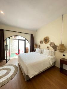 CipanasにあるEls Villas Garutの大きな白いベッドと窓のある寝室
