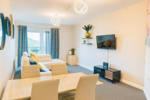 Una sala de estar con una mesa y sillas y un sofá. en Hastings Apartments Extra Large Self Catering Apt Tourism Certified Free Parking WiFi, en Belfast