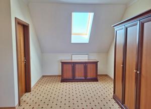 une chambre mansardée avec une petite armoire et une fenêtre dans l'établissement Balmer See 28 Fereinwohnung für Golfer, à Balm