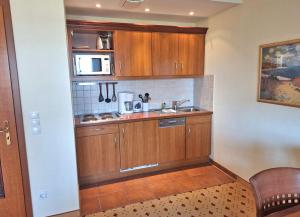 a kitchen with wooden cabinets and a microwave at Balmer See 28 Ferienwohnung mit direktem Seeblick in Balm +11 photos