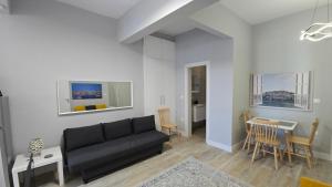 a living room with a black couch and a table at KYANA Luxury KVA in Kavála
