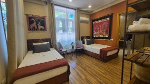 a room with two beds and a window at Explorers Kilimanjaro Boutique Hotel in Moshi