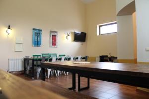 a conference room with a table and chairs and a tv at El Albergue de Herrera in Herrera de Pisuerga