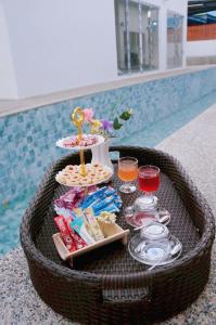 a tray of food and drinks in a basket next to a pool at A&J Holiday Villa in Ban Na Bon