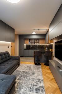 een woonkamer met een bank en een bar bij Family and Business apartment Free street parking in Stara Zagora