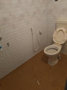 Baño con aseo y manguera en la pared en mithra house, en Khammam