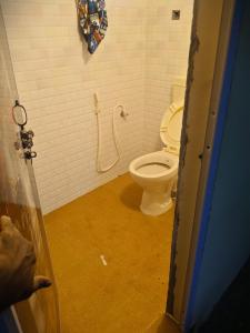 een badkamer met een wit toilet in een stal bij mithra house in Khammam