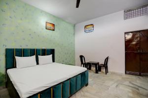 Un dormitorio con una cama y una mesa dentro. en Hotel O LJP Farm House, en Harduāganj 23 fotos más