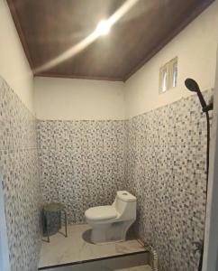 a bathroom with a white toilet in a room at Satera Homestay in Seteluk +16 photos