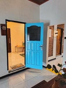 a blue door in the middle of a room at Satera Homestay in Seteluk