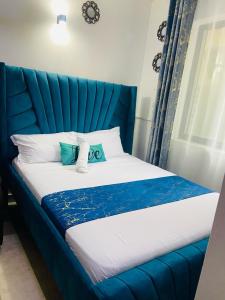 Una cama azul con dos almohadas encima. en Murangiri Accommodations, en Mombasa